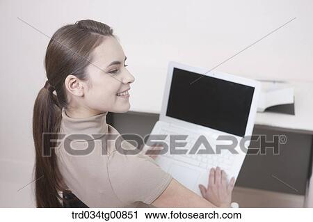 Stock Image - The smiling woman with the laptop . Fotosearch