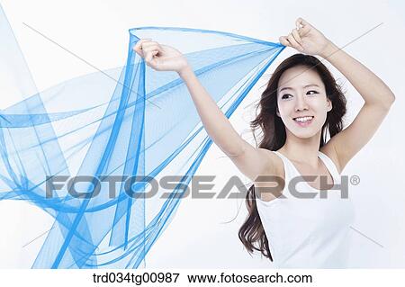 Stock Photo - The smiling woman with the windblown blue cloth. Fotosearch