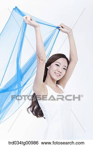 The smiling woman with the windblown blue cloth View Large Photo Image Stock Photograph - The smiling woman with the windblown blue cloth. Fotosearch