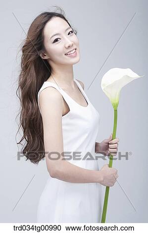 The smiling woman with white flower View Large Photo Image Stock Image - The smiling woman with white flower. Fotosearch