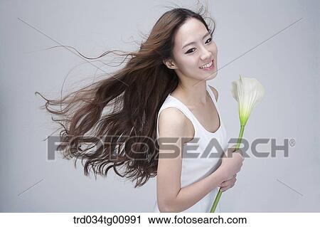 The smiling woman with white flower View Large Photo Image Stock Image - The smiling woman with white flower. Fotosearch