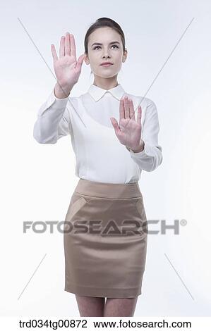 Stock Image - The standing woman with her touching palms from the side. Fotosearch