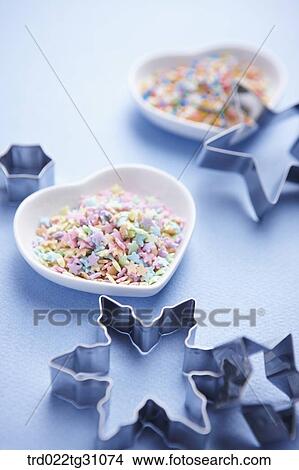 The star shaped cookie cutters with the dish of star decorating sugar View Large Photo Image Picture - The star shaped cookie cutters with the dish of star decorating sugar. Fotosearch
