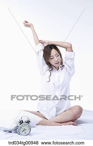 Stock Photo - The stretching woman on the bed. Fotosearch