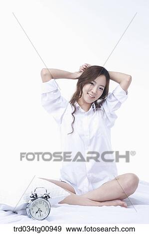 Stock Photo - The stretching woman on the bed. Fotosearch