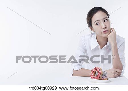 Stock Photo - The thinking woman with the doughnuts. Fotosearch