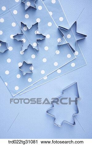 Stock Image - The various shapes of cookie cutters and the blue polka dots table napkin. Fotosearch