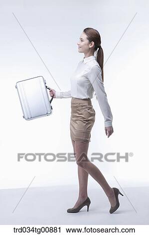 The walking woman with metal suitcase View Large Photo Image Stock Image - The walking woman with metal suitcase. Fotosearch