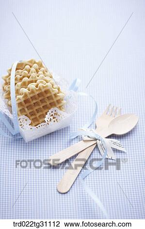Stock Image - The wattle served in the paper plate with the blue string and the wooden spoon and fork . Fotosearch