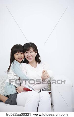 The woman and girl hugging together on the couch View Large Photo Image Stock Image - The woman and girl hugging together on the couch. Fotosearch