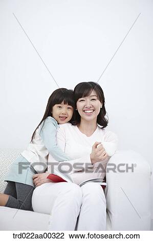 The woman and girl hugging together on the couch View Large Photo Image Stock Image - The woman and girl hugging together on the couch. Fotosearch