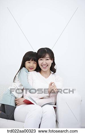 The woman and girl hugging together on the couch View Large Photo Image Stock Image - The woman and girl hugging together on the couch. Fotosearch