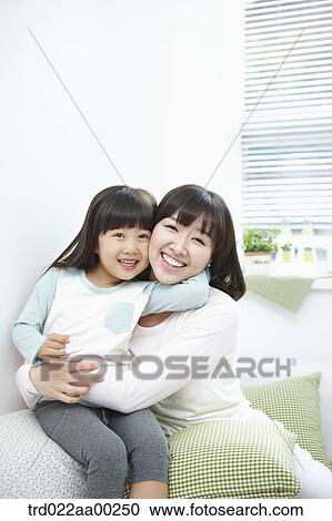 Stock Image - The woman and girl hugging together with big smile. Fotosearch