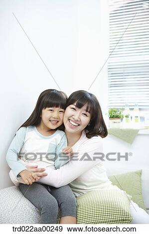 Stock Photo - The woman and girl hugging together with big smile. Fotosearch