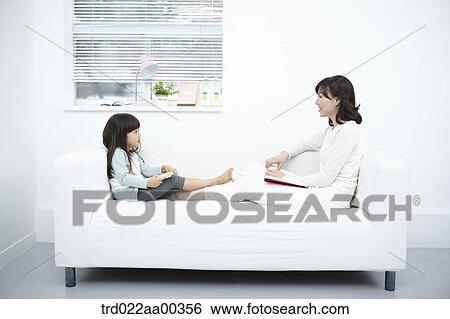 The woman and girl looking at each other with the book View Large Photo Image Stock Photograph - The woman and girl looking at each other with the book. Fotosearch