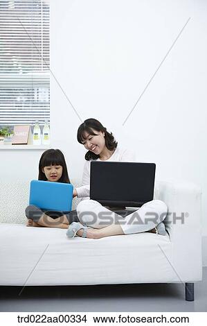 Picture - The woman and girl looking at the laptop . Fotosearch