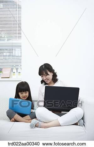 Stock Image - The woman and girl looking at the laptop . Fotosearch