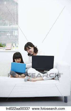 The woman and girl looking at the laptop  View Large Photo Image Stock Photo - The woman and girl looking at the laptop . Fotosearch