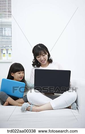 Stock Photo - The woman and girl looking at the laptop . Fotosearch