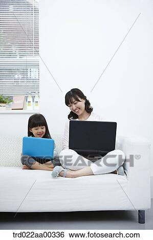 The woman and girl looking at the laptop View Large Photo Image Stock Photograph - The woman and girl looking at the laptop . Fotosearch