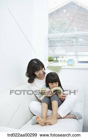 The woman and girl reading a book together View Large Photo Image Stock Photo - The woman and girl reading a book together. Fotosearch
