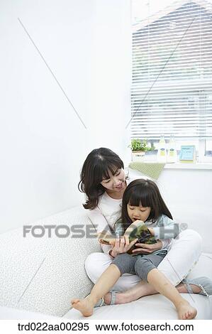 The woman and girl reading a book together View Large Photo Image Stock Photography - The woman and girl reading a book together. Fotosearch