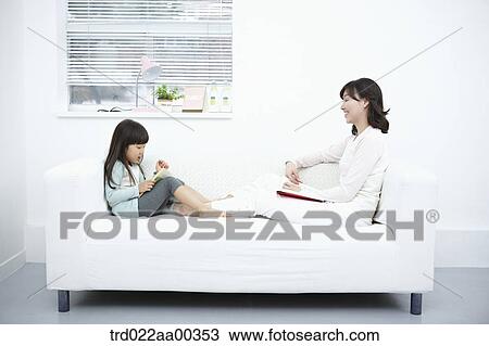 The woman and girl reading the book on the couch View Large Photo Image Stock Image - The woman and girl reading the book on the couch. Fotosearch