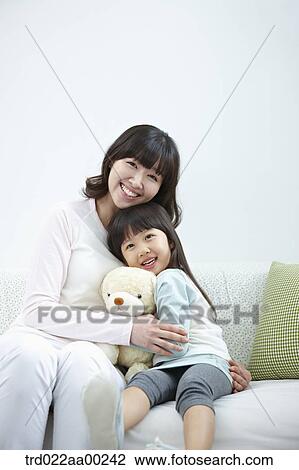 The woman and girl sitting with the teddy bear View Large Photo Image Stock Image - The woman and girl sitting with the teddy bear. Fotosearch