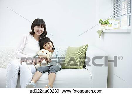 The woman and girl sitting with the teddy bear View Large Photo Image Stock Photo - The woman and girl sitting with the teddy bear. Fotosearch