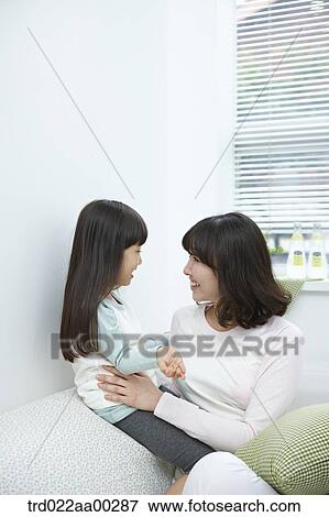Stock Photo - The woman and girl smiling at each other. Fotosearch