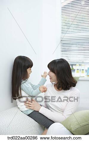 Stock Photograph - The woman and girl smiling at each other. Fotosearch