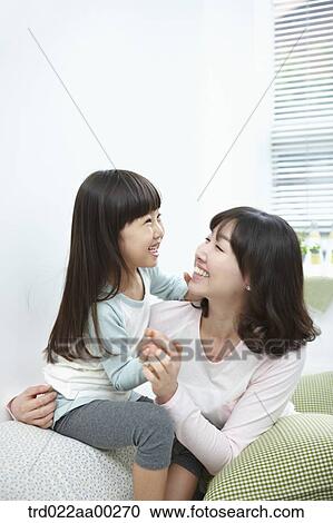 Stock Image - The woman and girl smiling together. Fotosearch