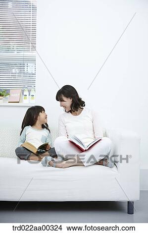 The woman and girl with the books smiling at each other View Large Photo Image Picture - The woman and girl with the books smiling at each other. Fotosearch