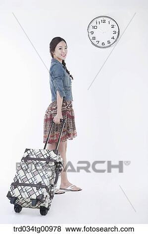 The woman dragging the suit case with a clock View Large Photo Image Stock Photo - The woman dragging the suit case with a clock . Fotosearch