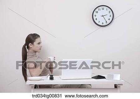 The woman holding a cup of coffee in the office View Large Photo Image Stock Image - The woman holding a cup of coffee in the office. Fotosearch