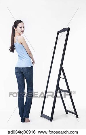 Stock Photograph - The woman in front of the mirror. Fotosearch