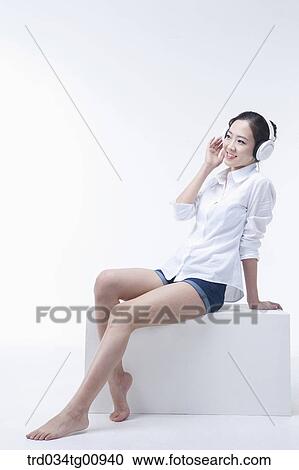 The woman listening to music with the headphone on View Large Photo Image Stock Image - The woman listening to music with the headphone on . Fotosearch