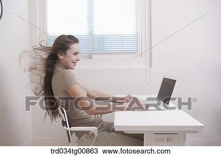 The woman looking at the laptop with windblown hair View Large Photo Image Stock Image - The woman looking at the laptop with windblown hair. Fotosearch