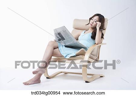 The woman reading newspaper on the chair View Large Photo Image Picture - The woman reading newspaper on the chair. Fotosearch