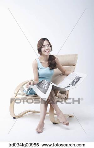 The woman reading newspaper on the chair View Large Photo Image Stock Photography - The woman reading newspaper on the chair. Fotosearch
