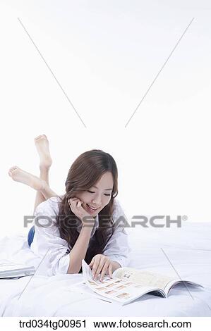 The woman reading the magazine on the bed View Large Photo Image Stock Image - The woman reading the magazine on the bed. Fotosearch