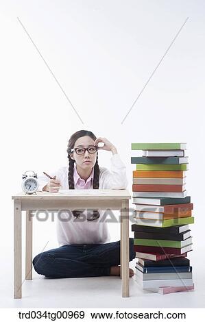 The woman studying with the pile of books View Large Photo Image Stock Photo - The woman studying with the pile of books. Fotosearch