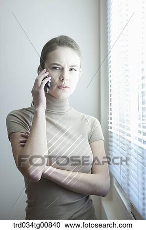 The woman talking on the phone by the window View Large Photo Image Stock Image - The woman talking on the phone by the window. Fotosearch