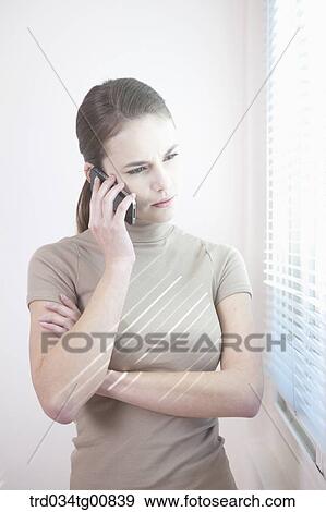 The woman talking on the phone by the window View Large Photo Image Stock Photo - The woman talking on the phone by the window. Fotosearch