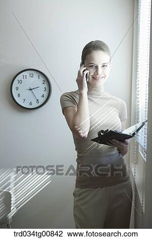 The woman talking on the phone with the planner View Large Photo Image Stock Image - The woman talking on the phone with the planner. Fotosearch