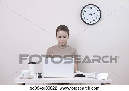 The woman typing the laptop in the office View Large Photo Image Stock Image - The woman typing the laptop in the office. Fotosearch
