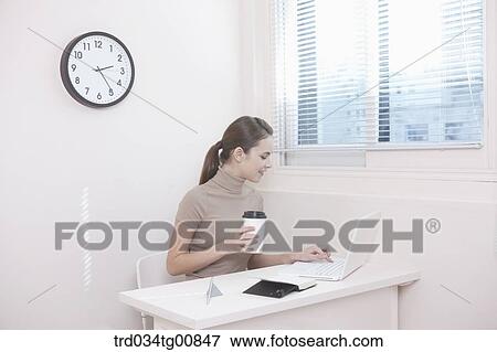 The woman typing the laptop in the office View Large Photo Image Stock Photo - The woman typing the laptop in the office. Fotosearch
