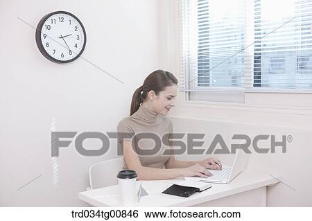 The woman typing the laptop in the office View Large Photo Image Stock Photograph - The woman typing the laptop in the office. Fotosearch
