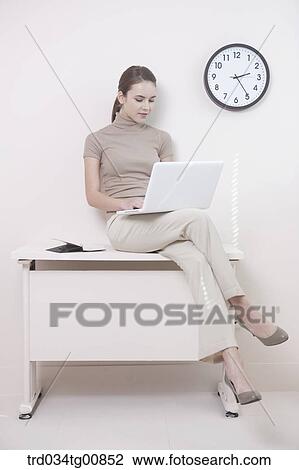 The woman typing the laptop on the desk View Large Photo Image Stock Image - The woman typing the laptop on the desk. Fotosearch