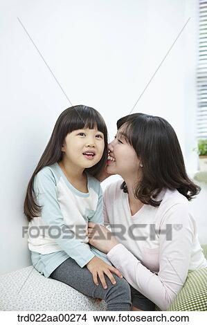 The woman whispering in girl's ear View Large Photo Image Picture - The woman whispering in girl's ear. Fotosearch